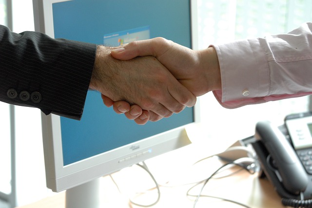 Two people shaking hands in professional setting